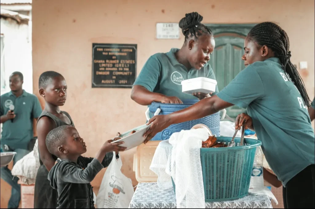 Volunteers serving food to children and families in need
